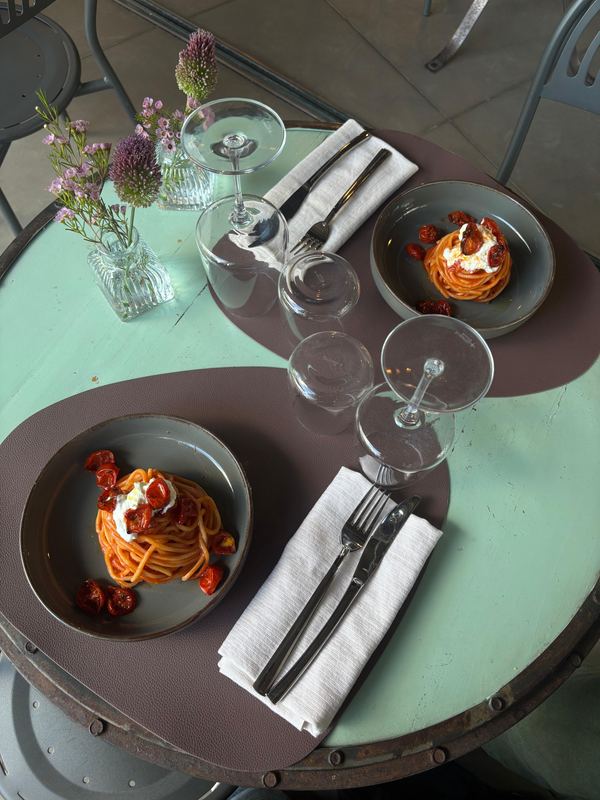 Due piatti di pasta al pomodoro su un tavolo apparecchiato